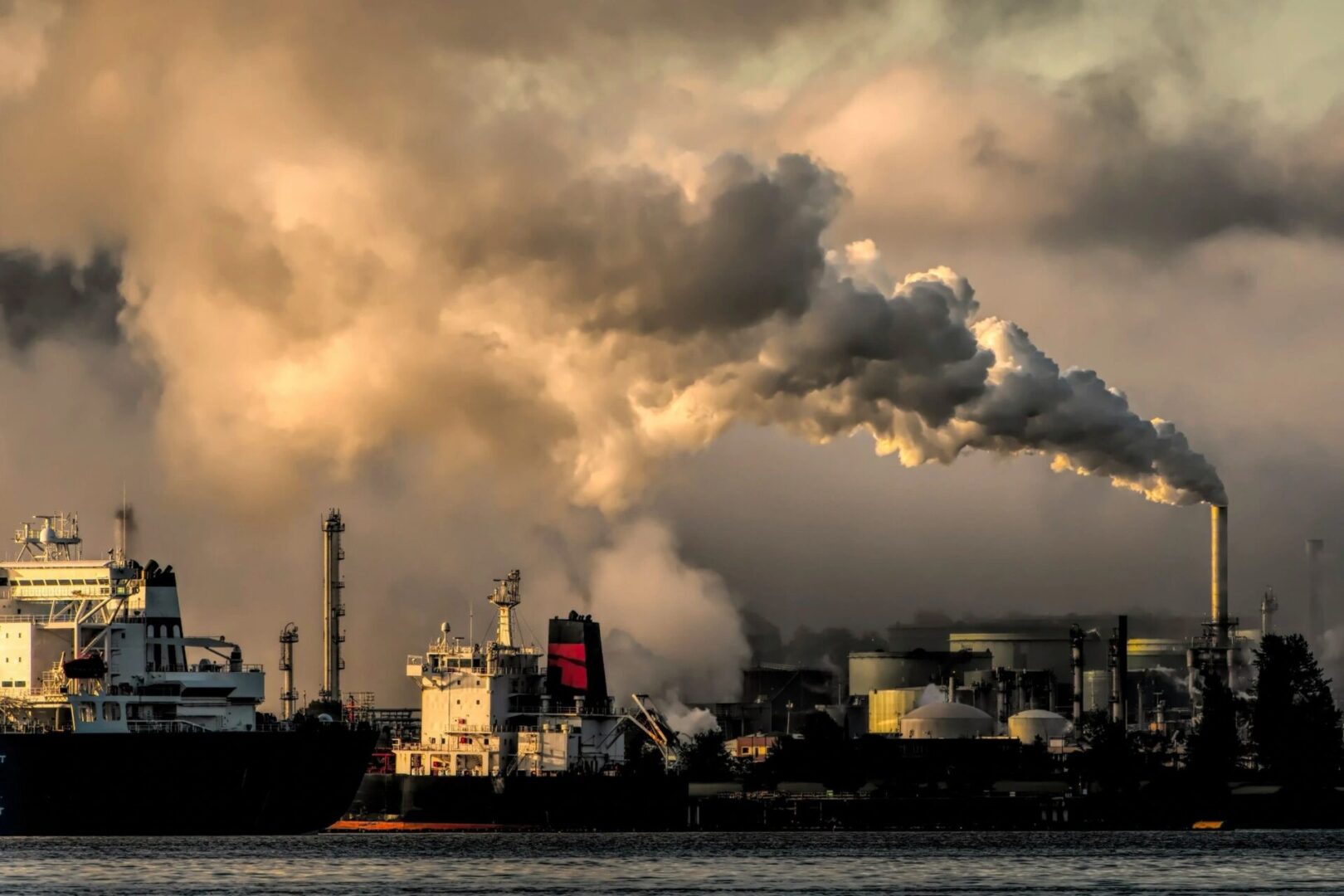 A factory with smoke coming out of the stacks.