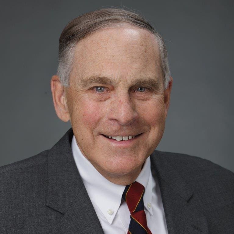 A man in a suit and tie smiling for the camera.